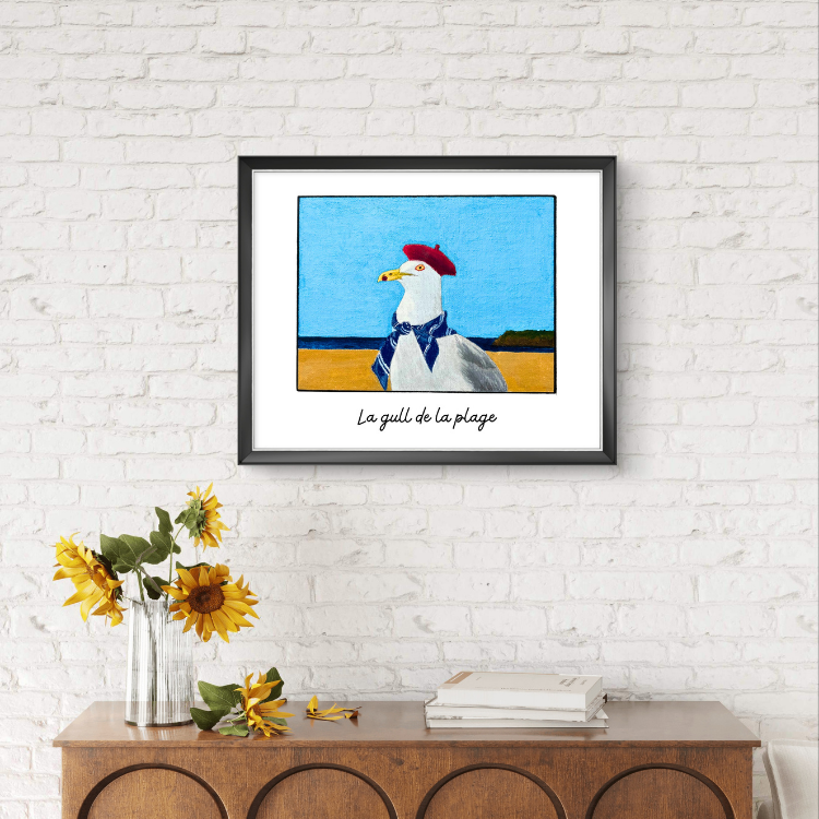 Framed artwork of a seagull with a red hat on a white brick wall above a wooden console table.