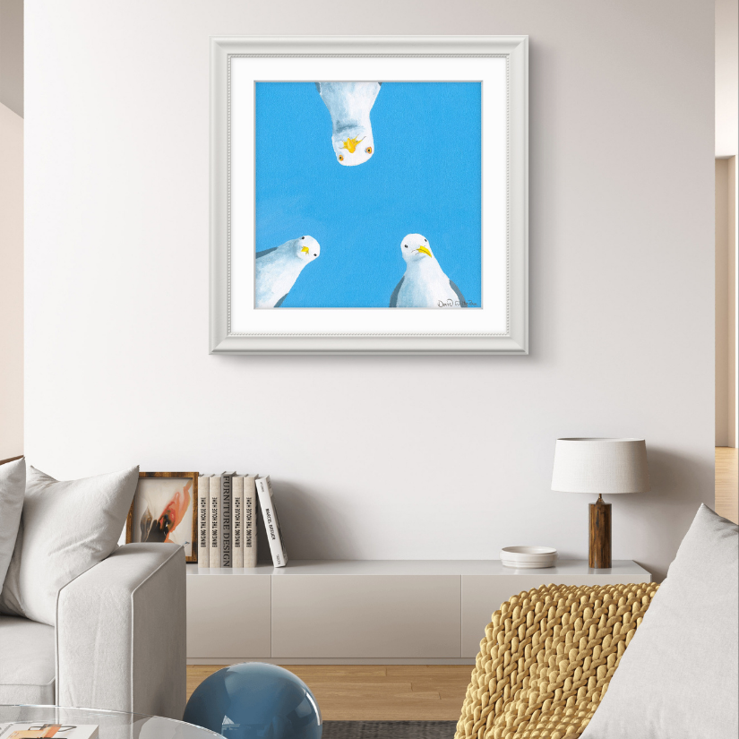 Framed artwork of three seagulls against a blue sky in a living room setting.